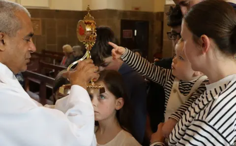 A young child points to the relic