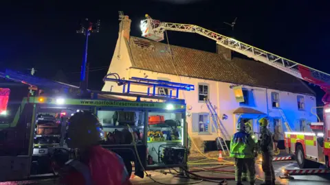 Firefighters at the scene of a fire at the Rising Sun pub