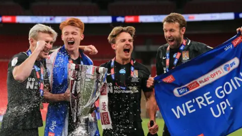 Getty Images Four Northampton Town players celebrate winning the 2020 League Two play-off final. 