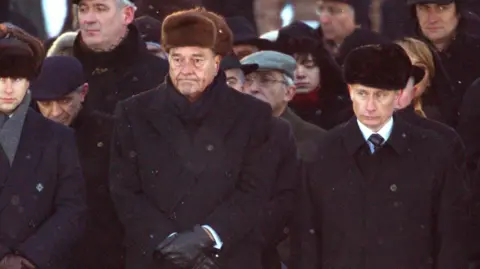 Getty Images Vladimir Putin (gambar di sebelah mantan Presiden Prancis Jacques Chirac) menghadiri upacara 2005 di Polandia memperingati peringatan 60 tahun pembebasan Auschwitz 