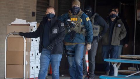 FBI agents raiding Feeding Our Future carry boxes of documents