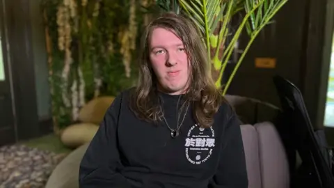 Ryan, who is classified as Neet, sat in an arm chair. He is staring into the camera.