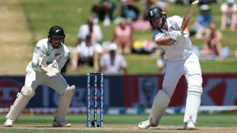 England's Gus Atkinson hits out, watched by New Zealand wicketkeeper Tom Blundell, in 2024