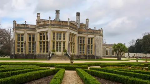 Getty Images A shot of Highcliffe Castle, a large stately home. In the foreground are rows of immaculately trimmed hedges. 