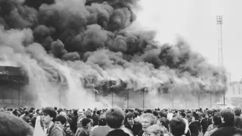 Getty Images Fire at Valley Parade and fans on the pitch