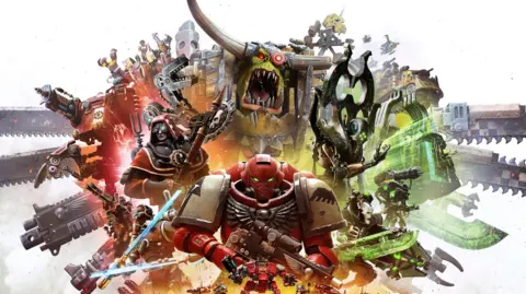 Games Workshop An artist's rendering shows a space marine in red armour standing in front of a mass of grotesque enemies - they are a mass of orcs, robots and weapons.