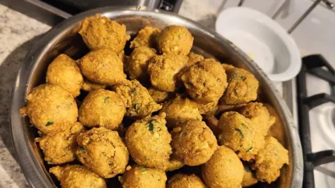 Gina Agnew The a silver bowl full of the golden-coloured fried snack in a home kitchen.