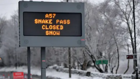 A sign saying the road is closed due to snow