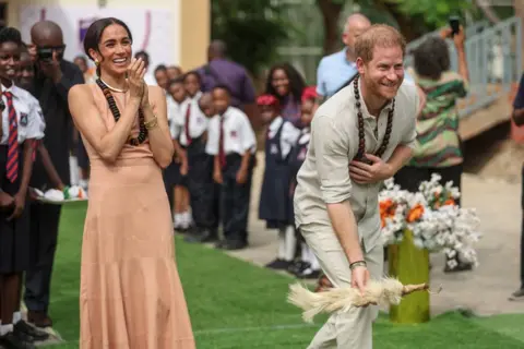KOLA SULAIMON/AFP The Duke and Duchess of Sussex take part in activities at the Lightway Academy in Abuja, Nigeria