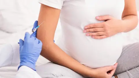 Prostock-Studio Pregnant woman holds abdomen