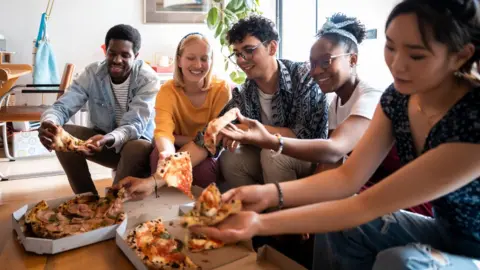 Getty Images Housemates sharing a pizza