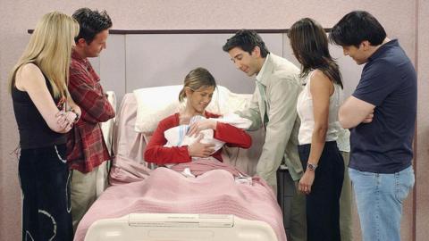A still from the episode with all the main Friends cast in shot, Rachel is holding a baby