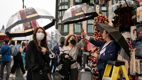 PA Media Women purchasing umbrellas in Westminster