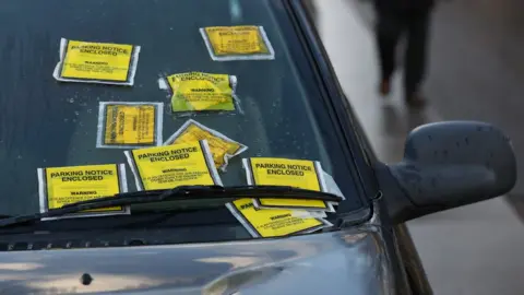 PA Media Nine parking tickets on a car windscreen