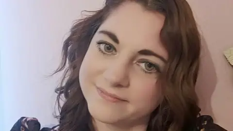 Camilla Ridd Camilla Ridd has curly brown hair and has slanted her head slightly to the right for this picture, which she offers a slight smile in.