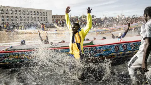AFP Supporters cheer as their teams pirogue is unveiled in the fishing village of Guet N'Dar in Saint-Louis in Senegal - Saturday 23 July 2022