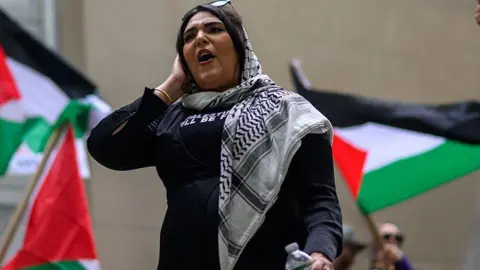 Nerdeen Kiswani speaks during a protest commemorating Nakba Day on May 15, 2025 in the Brooklyn borough of New York City as Palestinian flags wave behind her.