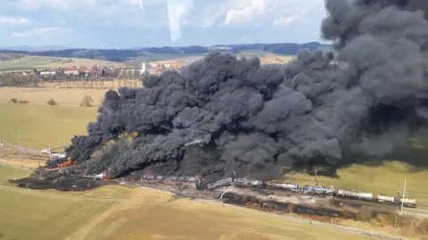 Hasiči Olomouc A drone shot showing large plumes of black smoke coming from the derailed train