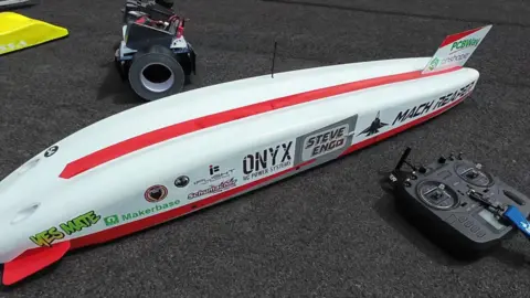 The image shows 'The Mach Reaper' remote control car lying on the ground.