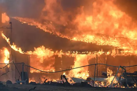 Getty Images Smoke and Flames komen uit het bos terwijl bemanningen proberen een natuurbrand te blussen in Chico, Californië, Verenigde Staten op 25 juli 2024. (Foto door Tayfun Coskun/Anadolu via Getty Images)