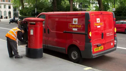 Getty Images A Royal Mail post van next to a post box where a postal worker is emptying letters