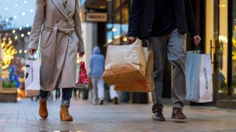 Getty Images Pembeli membawa tas Macy's dan Nordstrom di Broadway Plaza di Walnut Creek, California, AS, pada Senin, 16 Desember 2024