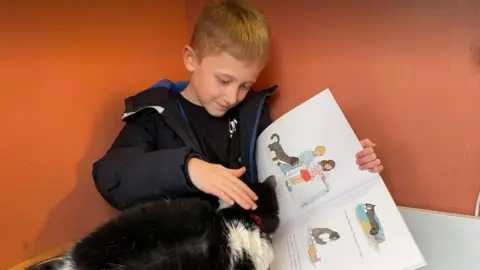 BBC Boy reading to a cat