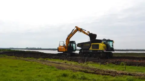 National Trust/PA Media Sea embankment being lowered at Northey Island