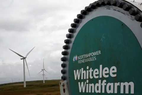 Getty Images A sign for Whitelee Windfarm with turbines in the background.