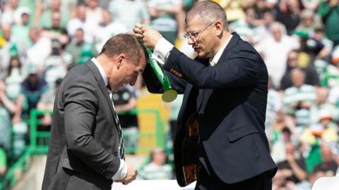 Celtic manager Brendan Rodgers receives his winners' medal from Neil Doncaster