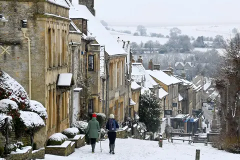 Reuters People walk through snow in Burford, 28 December 2020