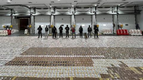 Security forces guard the 5,630 packs of cocaine they seized at a port near Guayaquil