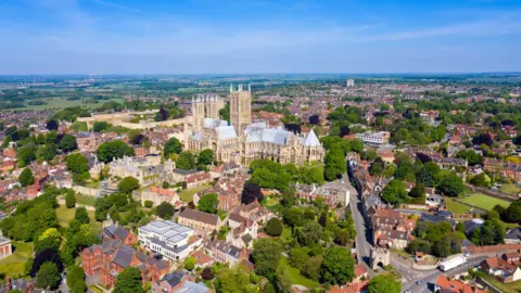 Getty Images An aerial view of Lincoln city, with the Minster in a prominent position. It is a clear and sunny day and the trees are in full leaf.