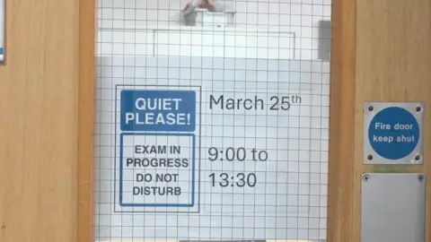 A door with a sign on it saying quiet please, exam in progress