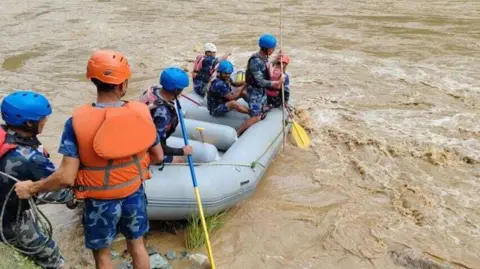 NEPAL'S NATIONAL DISASTER RISK REDUCTION AND MANAGEMENT AUTHORITY / HANDOUT Search and rescue efforts continue after a landslide hit two passenger buses in Chitwan, Nepal on July 11, 2024. At least 65 people are missing after a landslide hit two passenger buses. The incident happened in the Chitwan district, some 86 kilometers (53 miles) west of the capital Kathmandu, when the landslide swept the buses into Trishuli River.