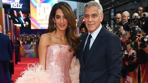 George and Amal Clooney on the red carpet at a movie premiere