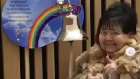 Family handout Sandie Griffin ringing the bell after her cancer treatment