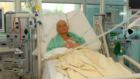 Getty Images Alexander Litvinenko lying successful  a infirmary  furniture  astatine  the Intensive Care Unit of University College Hospital successful  London connected  20 November 2006. There are aesculapian  machines astir   the furniture  and helium  is wearing a greenish  infirmary  gown. He is bald and tubes tin  beryllium  seen attached to his chest.