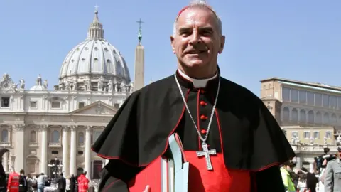Reuters Cardinal Keith O'Brien wearing cassock and with silver crucifix standing in St Peter's Square in Rome with St Peter's dome in the background