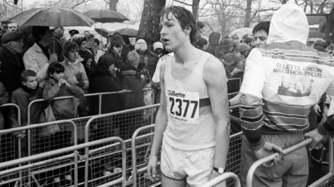 London Marathon Events Black and white photo of young Chris in the rain at the end of the marathon