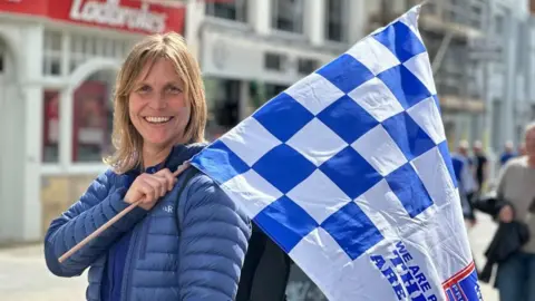 Alice Cunningham/BBC Rachel Aldridge holding a flag