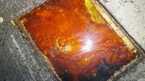 Large amount of orangey-red fat sitting in a drain