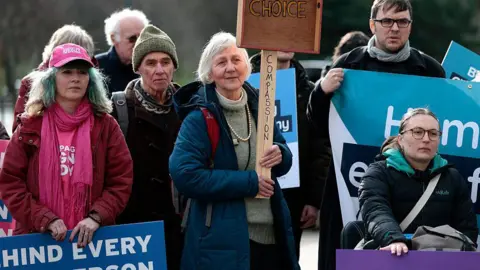 Getty Images A group of campaigners holding signs in favour of assisted dying