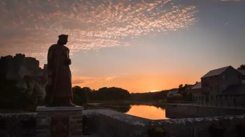 Mandy Llewellyn The Henry VII statue looking out to a sunset beside Pembroke Castle.