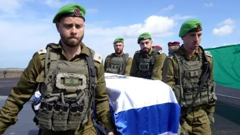 Israeli soldiers carrying a coffin draped in the Israeli flag