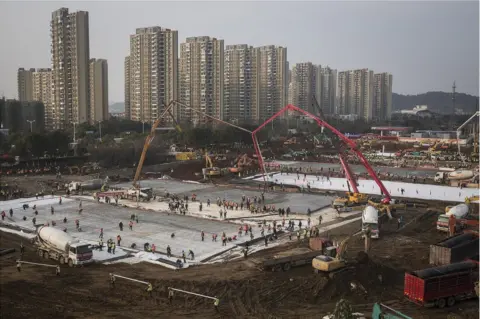Getty Images Hundreds of construction workers and heavy machinery build Huoshenshan hospital