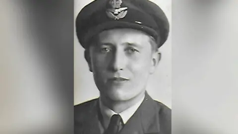 A photo of Patrick in RAF uniform, complete with cap, jacket, shirt and tie.