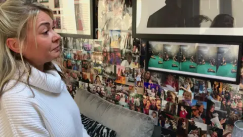 BBC/Seb Cheer A woman, Alison, looks at a wall filled with photographs of her daughter.