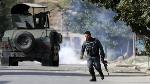 EPA Afghan police take positions near the intelligence training centre in Kabul attacked by gunmen. Photo: 16 August 2018