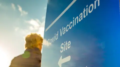 Getty Images Man walking into Covid vaccination centre